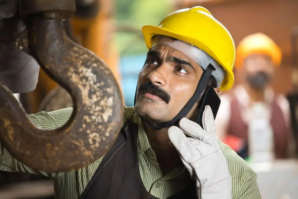 Worker distracted by mobile phone while operating machinery